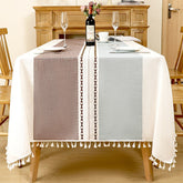 AIMHave modern abstract wave linen look tablecloth featuring fluid blue purple and orange geometric shapes with white tassels on a dining table