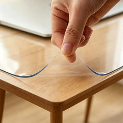 Hand lifting the corner of a PVC desk mat to show 1.5mm thickness and flexible, non-stick material.