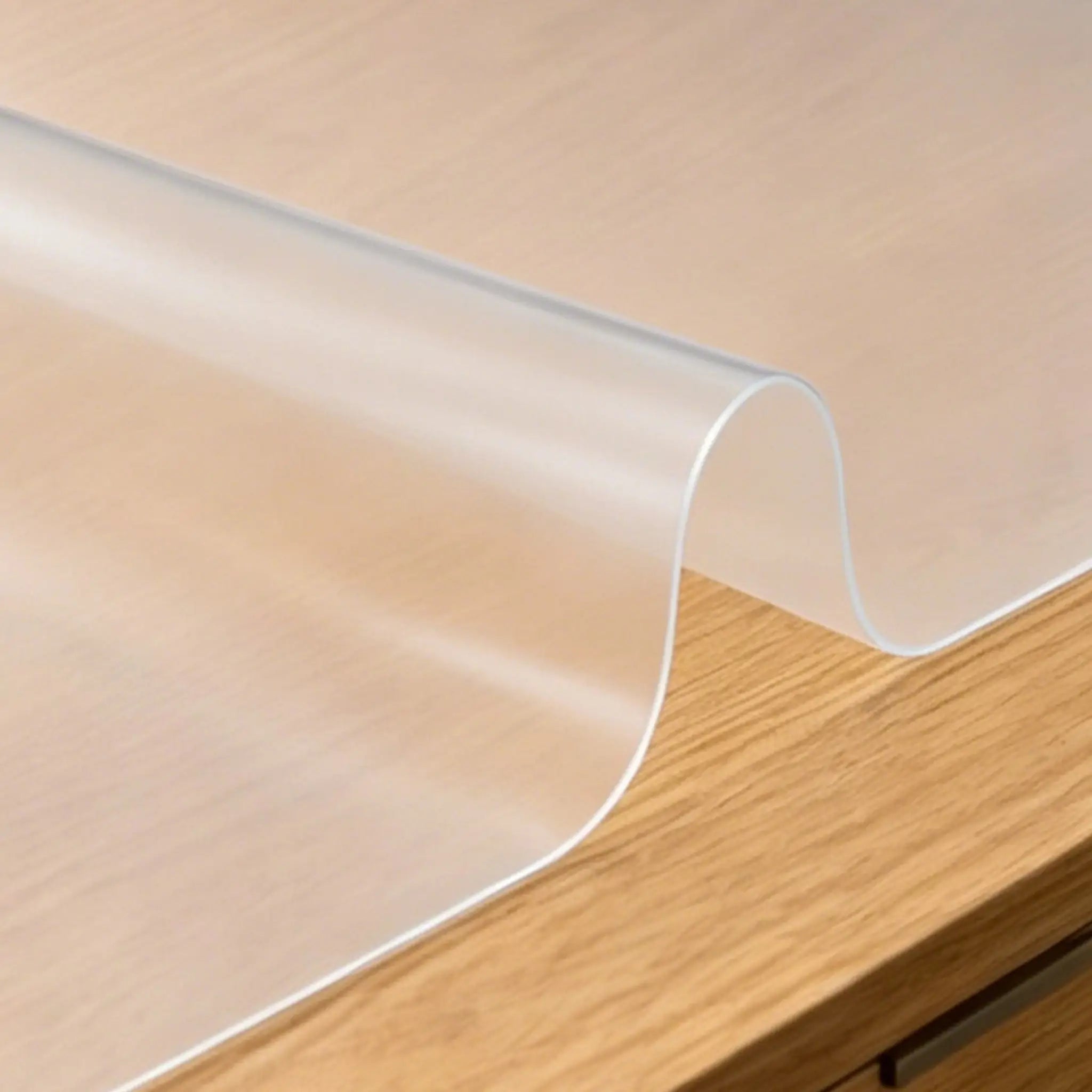 Frosted PVC mat showing high flexibility and translucent matte finish, perfect for protecting wooden tables.