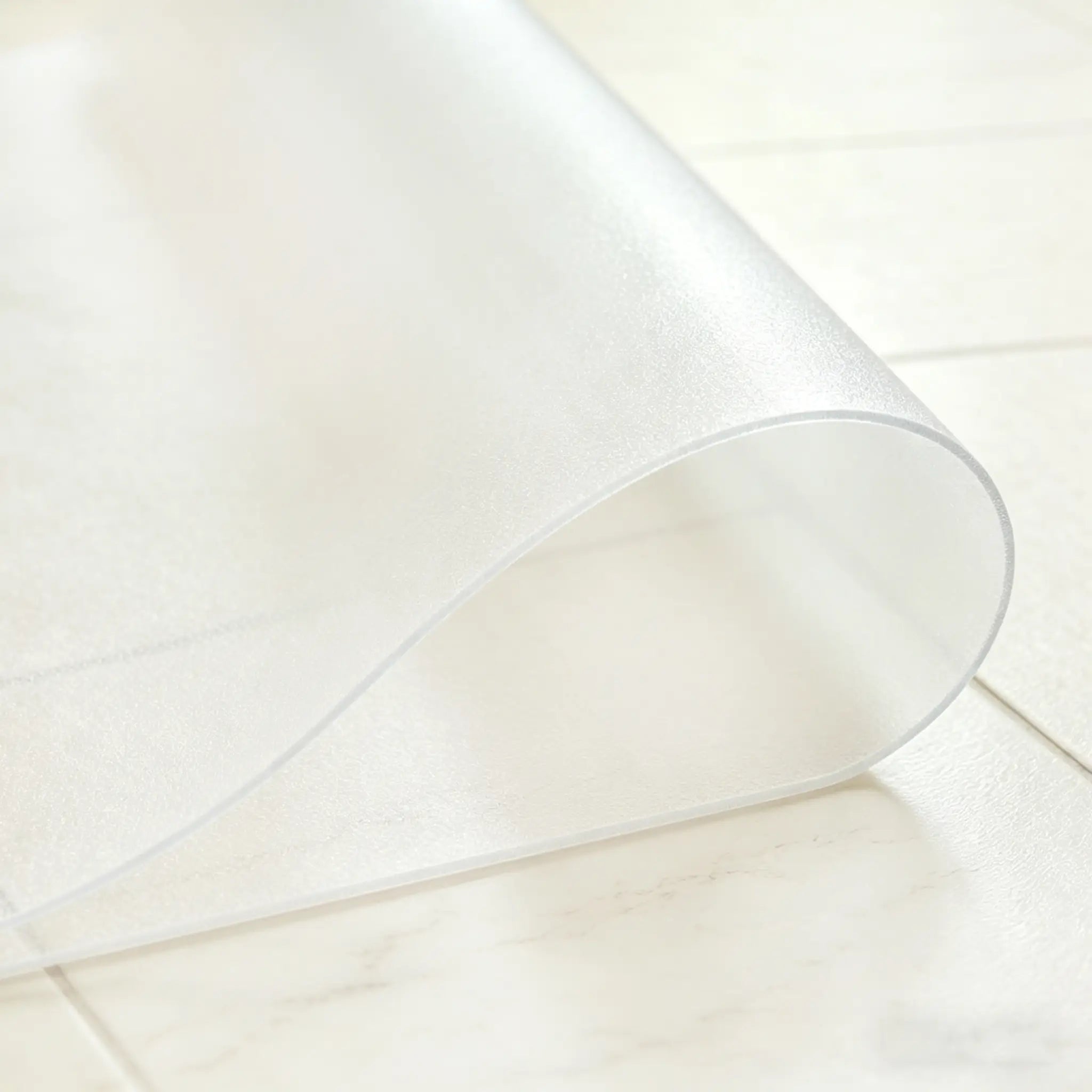Close-up of frosted PVC entrance mat being folded in the middle to demonstrate high flexibility and durability.