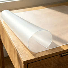 Close-up of frosted PVC mat with edge rolled up to demonstrate its soft texture and stay-flat design.