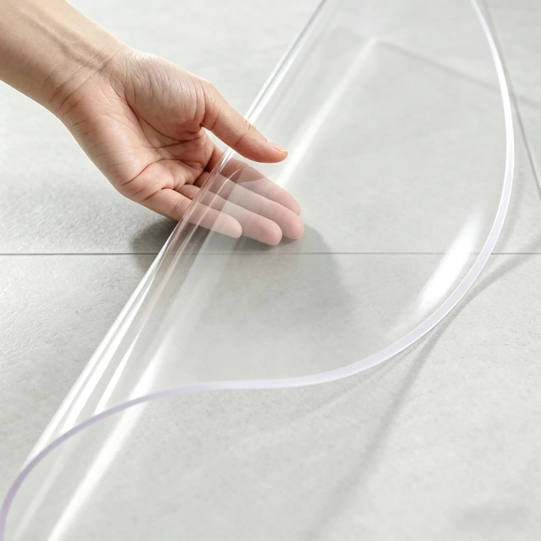 Hand folding a round clear PVC mat to demonstrate high flexibility and non-slip texture for bathroom floors.
