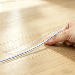 Pinching the edge of a round PVC mat to show 1.5mm thickness and clear, durable, and flexible material.