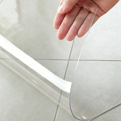 Hand folding a transparent kitchen mat to show 1.5mm thickness and premium flexible PVC material quality.