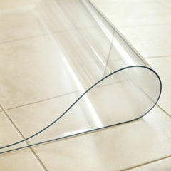 Close-up of transparent PVC laundry mat being folded in the middle to demonstrate durability and soft texture.