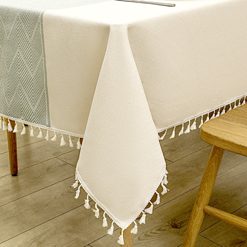 Close-up of elegant white macrame fringe tassels on an AIMHave burgundy red geometric diamond lattice faux linen tablecloth