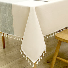 Close-up of elegant white macrame fringe tassels on an AIMHave burgundy red geometric diamond lattice faux linen tablecloth