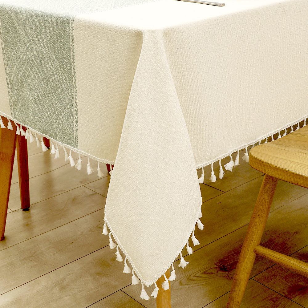 Close-up of elegant white macrame fringe tassels on an AIMHave sage green micro grid checkerboard faux linen tablecloth