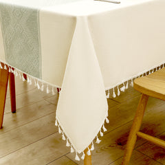 Close-up of elegant white macrame fringe tassels on an AIMHave sage green micro grid checkerboard faux linen tablecloth
