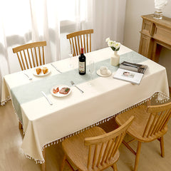Top view of AIMHave elegant Japandi minimalist woven green poly-cotton tablecloth styled with plates and croissants