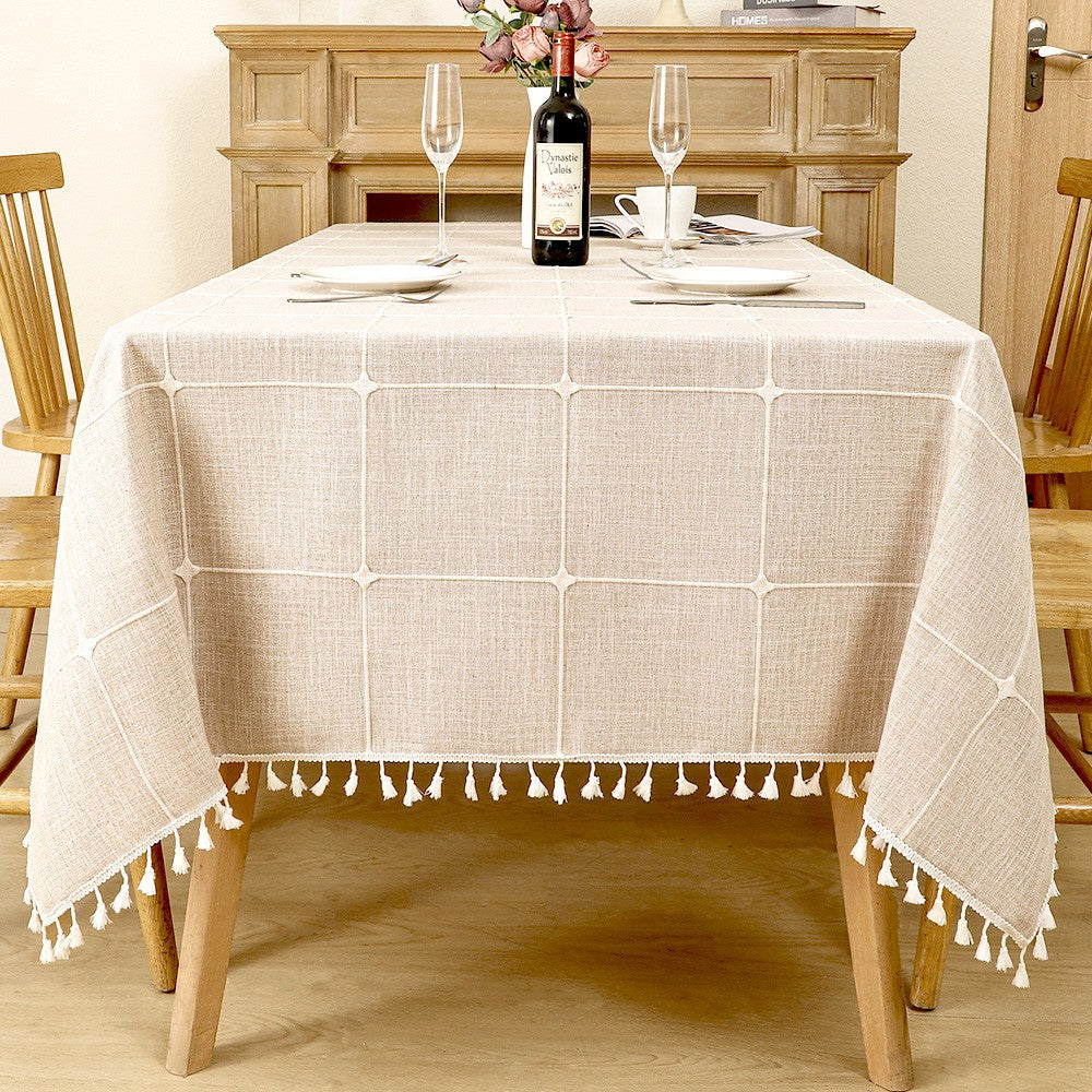 Classic grey and beige striped linen look tablecloth with white tassels on a farmhouse wooden dining table