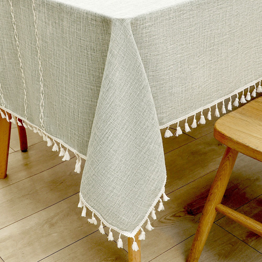 Close-up of elegant white macrame fringe tassels on an AIMHave grey oversized grid lattice faux linen tablecloth