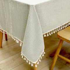 Close-up of elegant white macrame fringe tassels on an AIMHave grey oversized grid lattice faux linen tablecloth