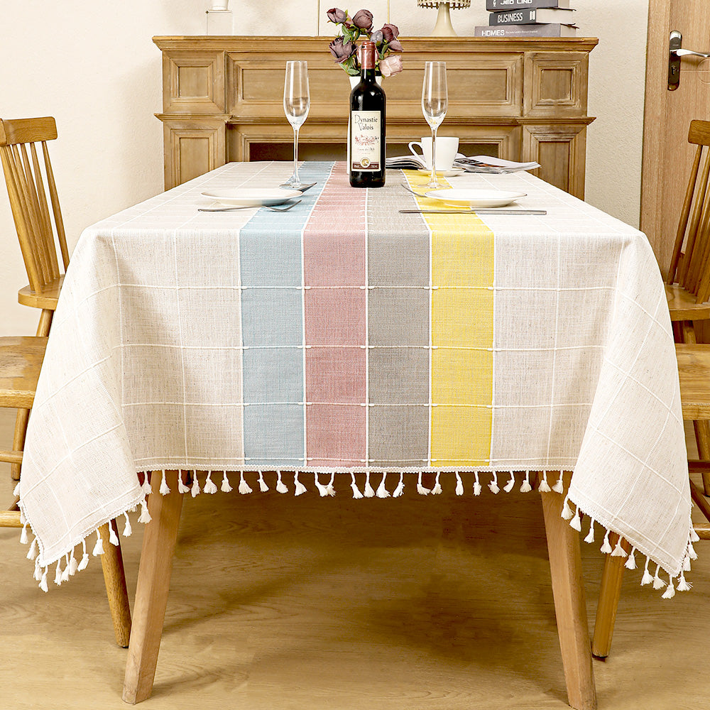 AIMHave modern abstract wave linen look tablecloth featuring fluid pink blue yellow and grey geometric shapes with white tassels on a dining table