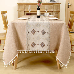 AIMHave modern abstract wave linen look tablecloth featuring fluid coffee brown and white geometric shapes with white tassels on a dining table