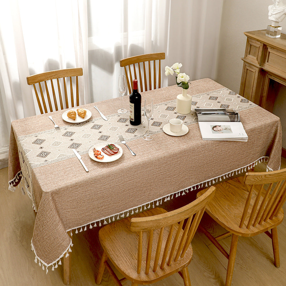 Top view of AIMHave luxury abstract fluid line patchwork coffee brown poly-cotton tablecloth styled with plates and croissants