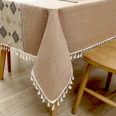 Close-up of elegant white macrame fringe tassels on an AIMHave coffee brown abstract curving line faux linen tablecloth