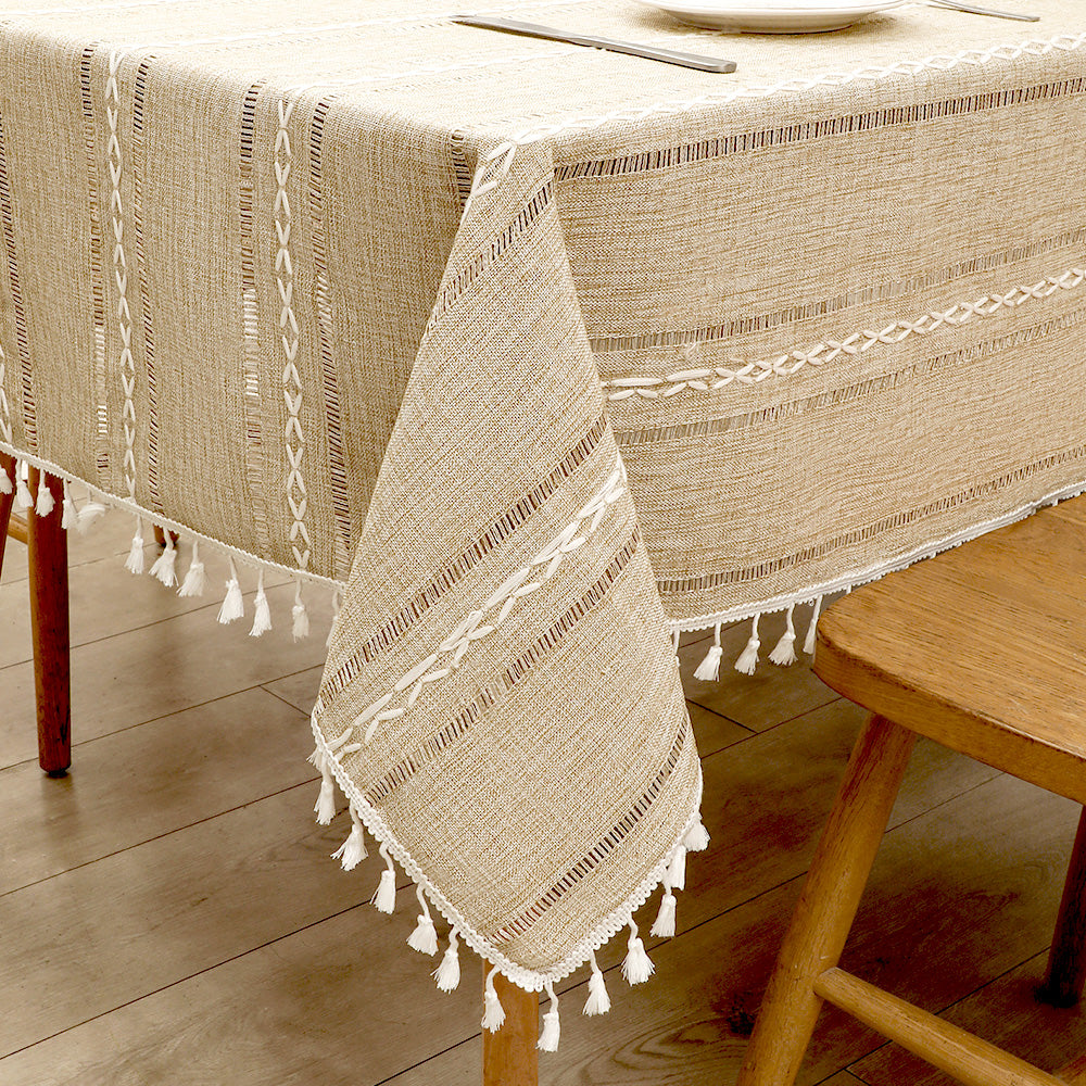 Close-up of elegant white macrame fringe tassels on an AIMHave coffee brown and cream striped faux linen tablecloth