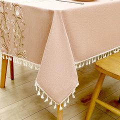 Close-up of elegant white macrame fringe tassels on an AIMHave dusty rose embroidered wildflower pattern tablecloth
