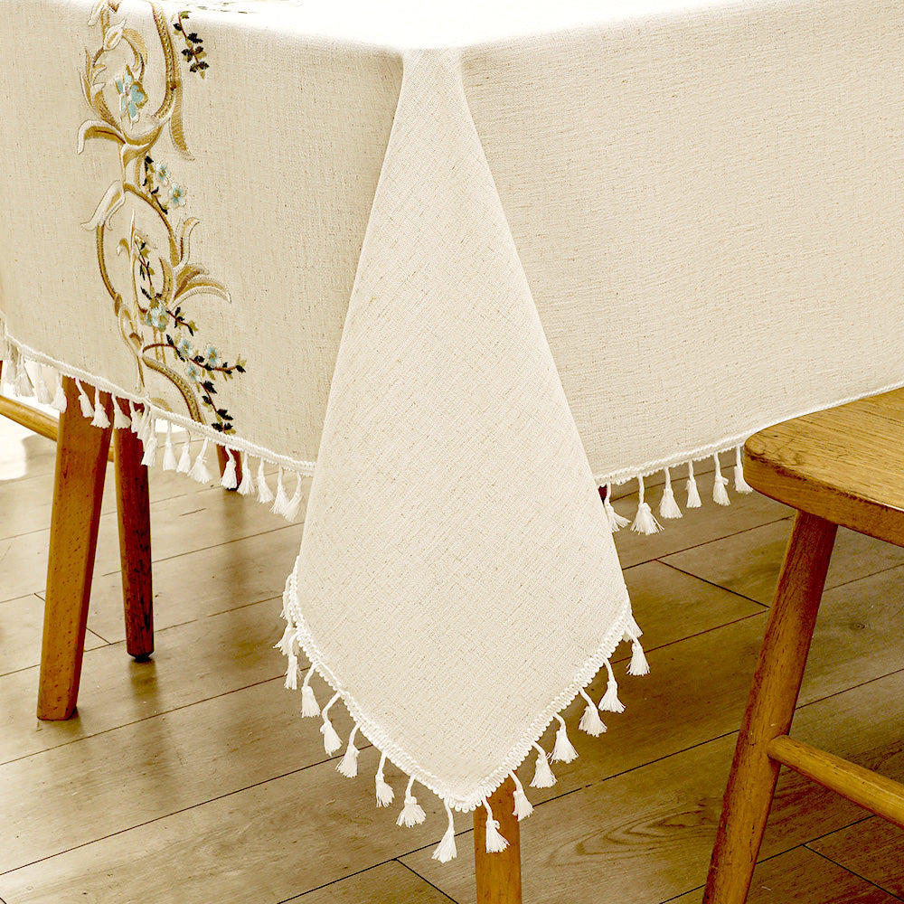 Close-up of elegant white macrame fringe tassels on an AIMHave luxury baroque gold and light blue embroidered tablecloth