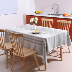 Cozy light-filled dining room table styled with an AIMHave modern Moroccan geometric tablecloth featuring white tassels and a white flower vase