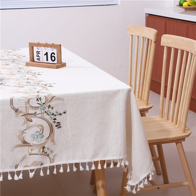 Side view closeup of AIMHave vintage luxury embroidered tablecloth with a calendar on the tabletop highlighting the detailed baroque stitching