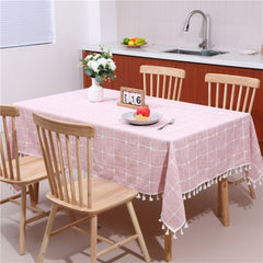 Cozy sunlit dining room table styled with an AIMHave vintage pink floral tablecloth featuring white tassels and a flower vase