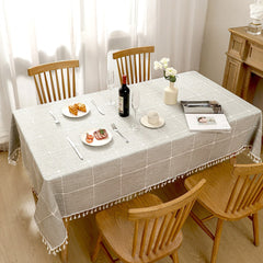 Top view of minimalist grey checkered poly-cotton tablecloth styled with plates and croissants