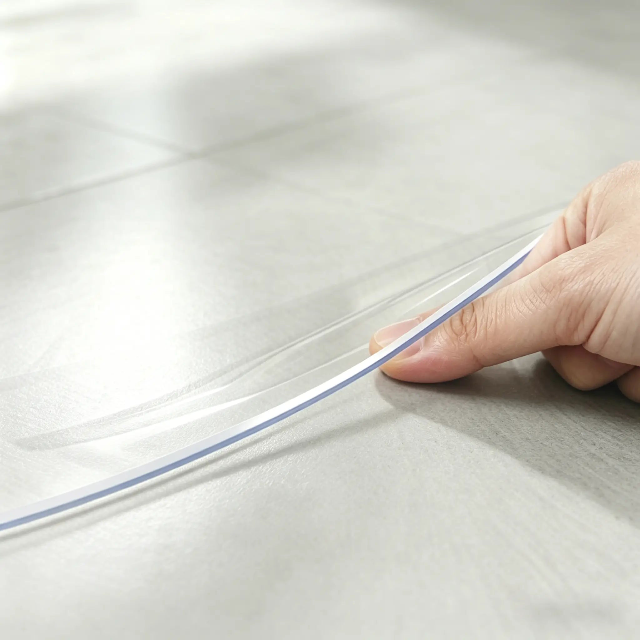 Close-up of round PVC mat edge being pinched to show 1.5mm thickness and crystal clear, high-quality material.