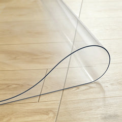 Close-up of transparent PVC entry mat being folded in the middle to show durability for high-traffic areas.