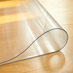 Close-up of transparent PVC pet mat being folded in the middle to demonstrate durability and soft texture.